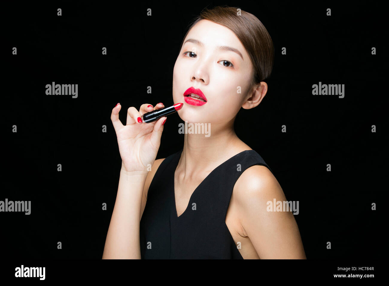 Porträt der jungen Frau in schwarz mit roten Lippen Stockfoto