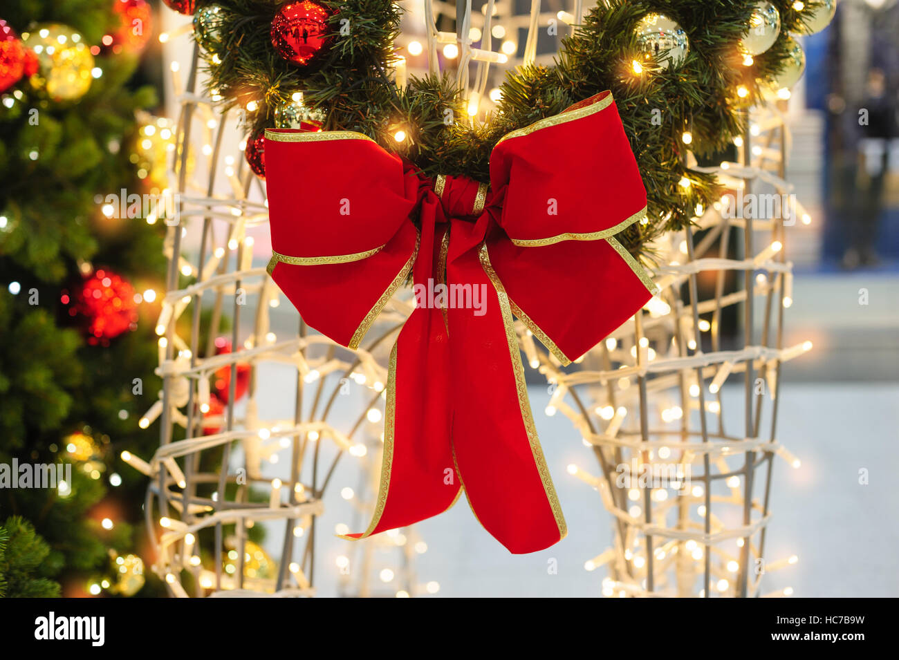 Rote Schleife an den Weihnachtsbaum im Park Stockfoto