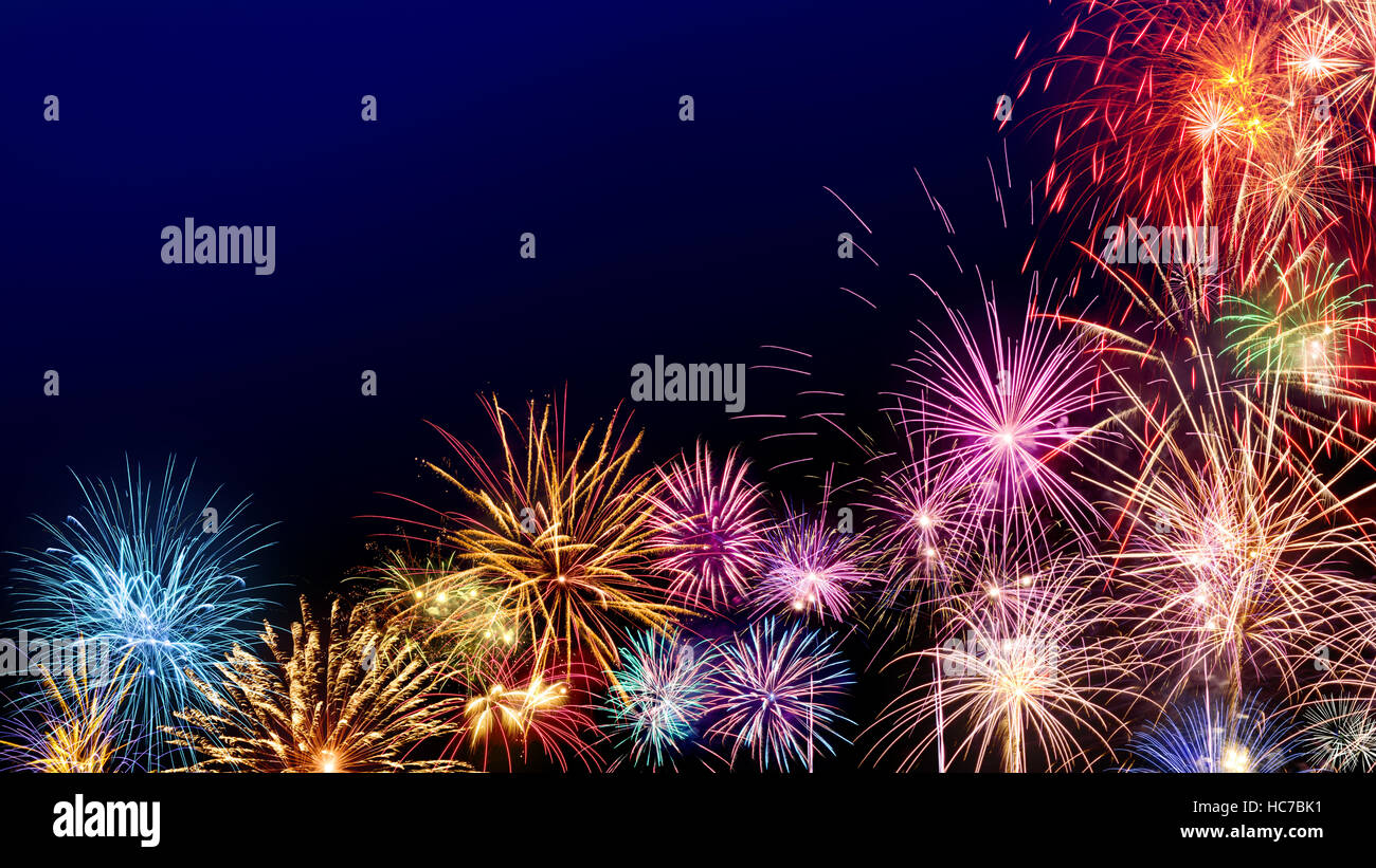 Bunten Feuerwerk als Grenze auf dunkelblauem Hintergrund, ideal für Silvester oder andere feste Stockfoto