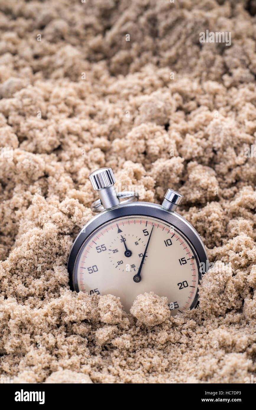 Chronometer, halb im Sand vergraben Stockfoto