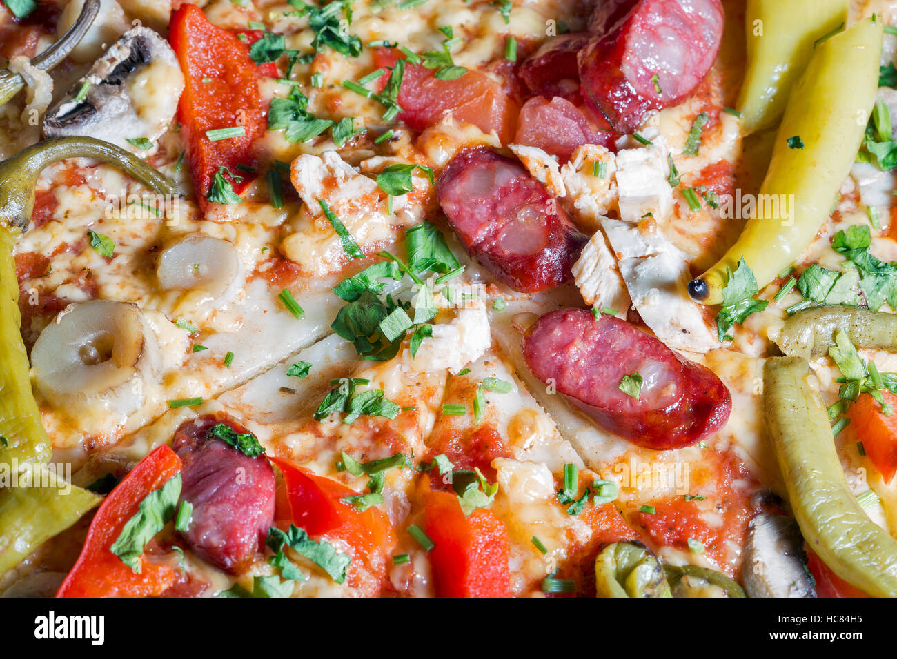 Pizza mit Salami, Wurst, Käse, Pfeffer und Pilzen. Closeup Hintergrund. Stockfoto