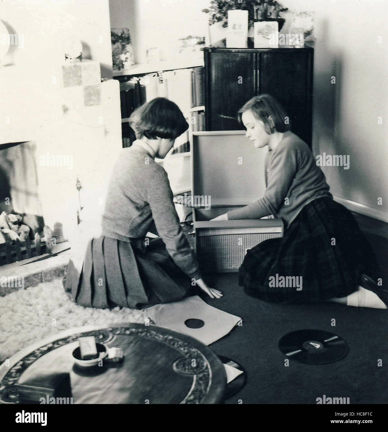 Historisches Archiv Bild zweier junger Frauen, die Datensätze auf dem Plattenspieler anhören. c1960s Stockfoto