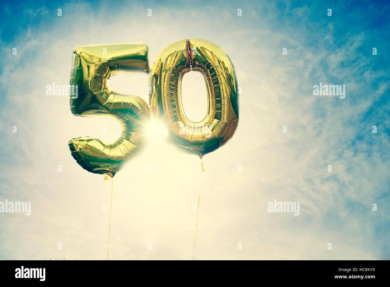 Heliumballons, die gegen einen blauen Himmel schweben und die Zahl 50 enthalten Stockfoto