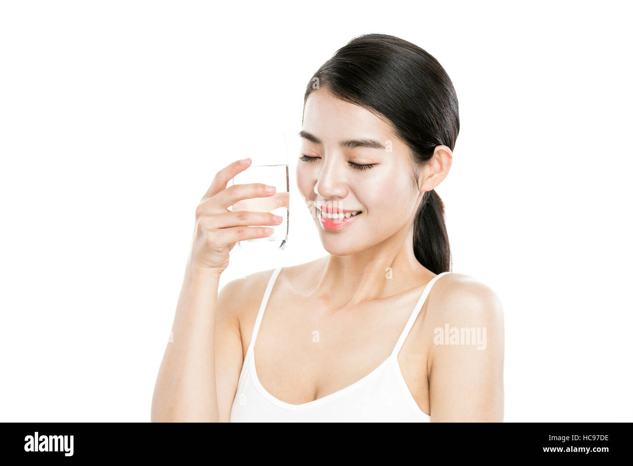 Porträt des jungen lächelnde Frau mit einem Glas Wasser, die Augen schließen Stockfoto