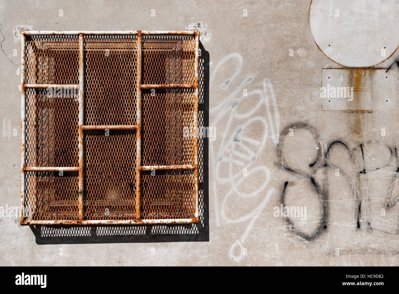 Fenster mit rostigen Bars und Graffiti an einem Gefängnis Stockfoto