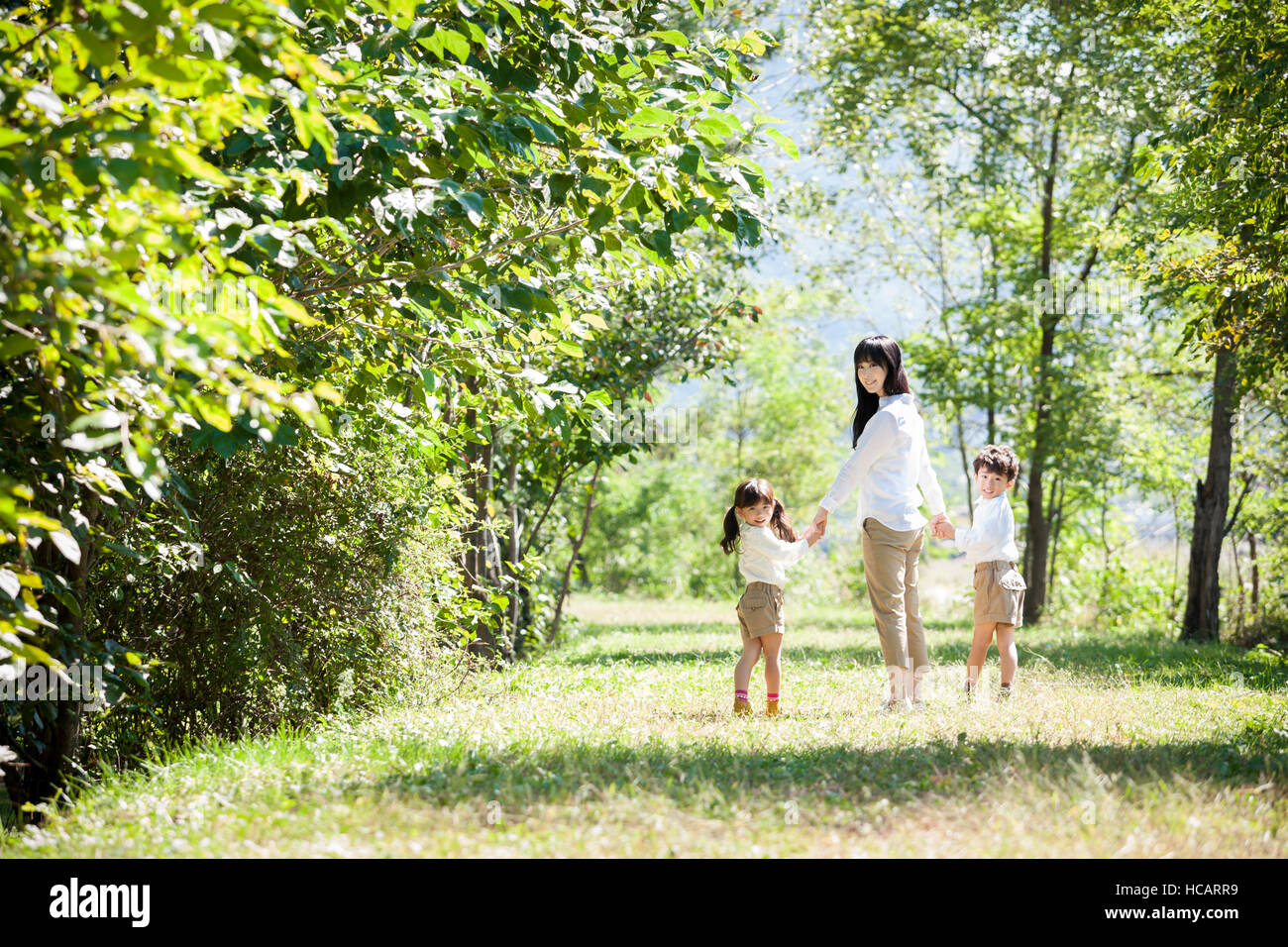 Liebevolle Mutter, Sohn und Tochter stehen Hand in der hand im Bereich Rückblick Stockfoto