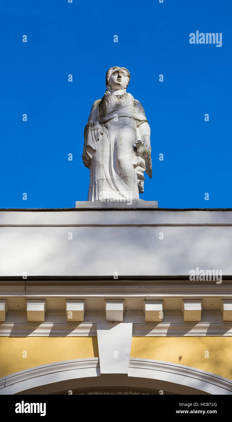 Skulptur einer Frau auf dem Dach des Gebäudes gegen den blauen Himmel Stockfoto