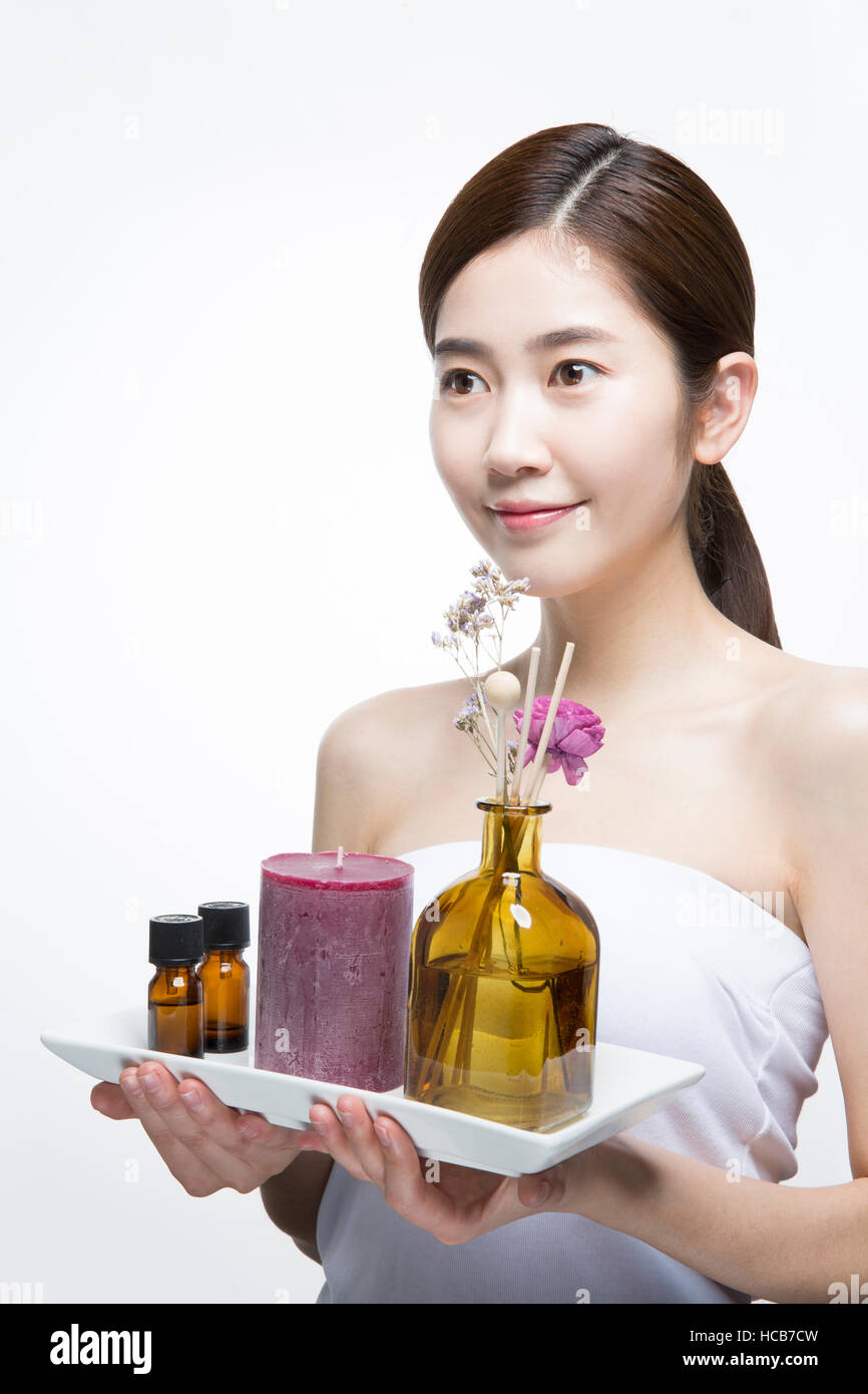 Porträt der jungen Frau mit ätherischen Aromaöl, Kerze und Diffusor Stockfoto