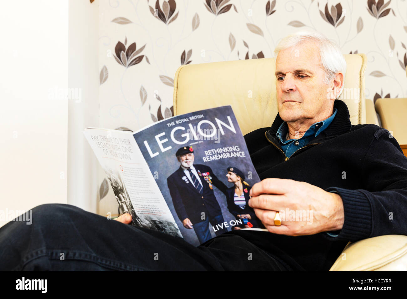 OAP Lesung British Legion Zeitschrift Mann liest setzte sich entspannen, mit Blick auf Magazin zu Hause UK England GB Stockfoto