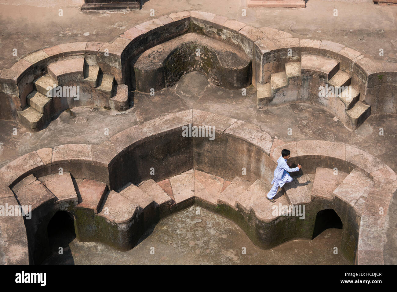 Ein Kind läuft im Hamam oder Pool am Jahaz Mahal in der Königlichen Enklave. Dieser Ort ist die wichtigste touristische Attraktion in Mandu, Madhya Pradesh, Indien Stockfoto