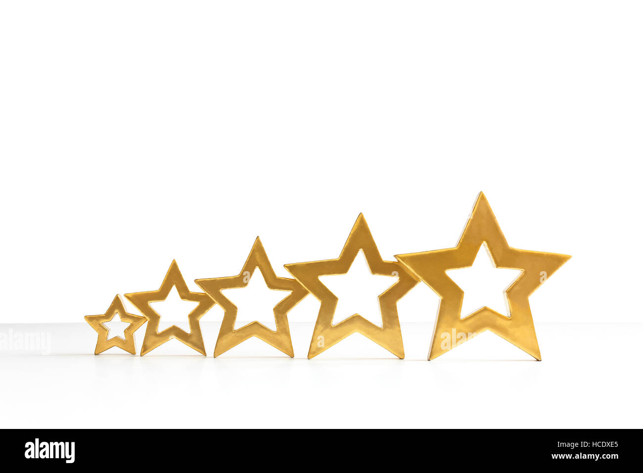 Fünf golden schimmernden Sternen in aufsteigender Reihenfolge auf weißem Hintergrund, Exemplar, Text Raum, Symbol für Top-performance Stockfoto