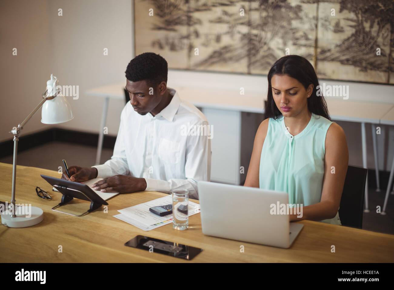 Geschäftsmann und einem Kollegen an ihrem Schreibtisch arbeiten Stockfoto