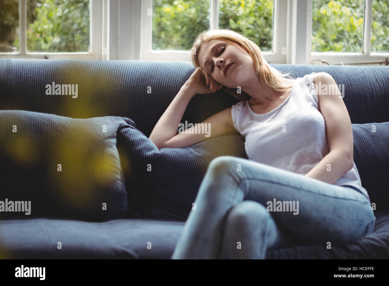 Schöne Frau am Sofa im Wohnzimmer entspannen Stockfoto