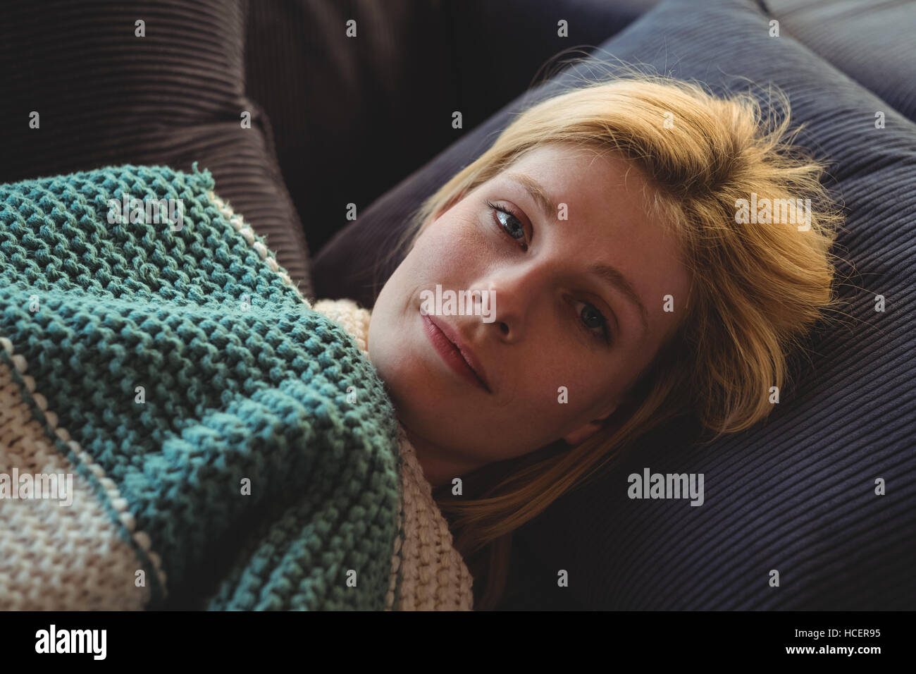 Portrait der schönen Frau liegend auf dem Sofa im Wohnzimmer Stockfoto