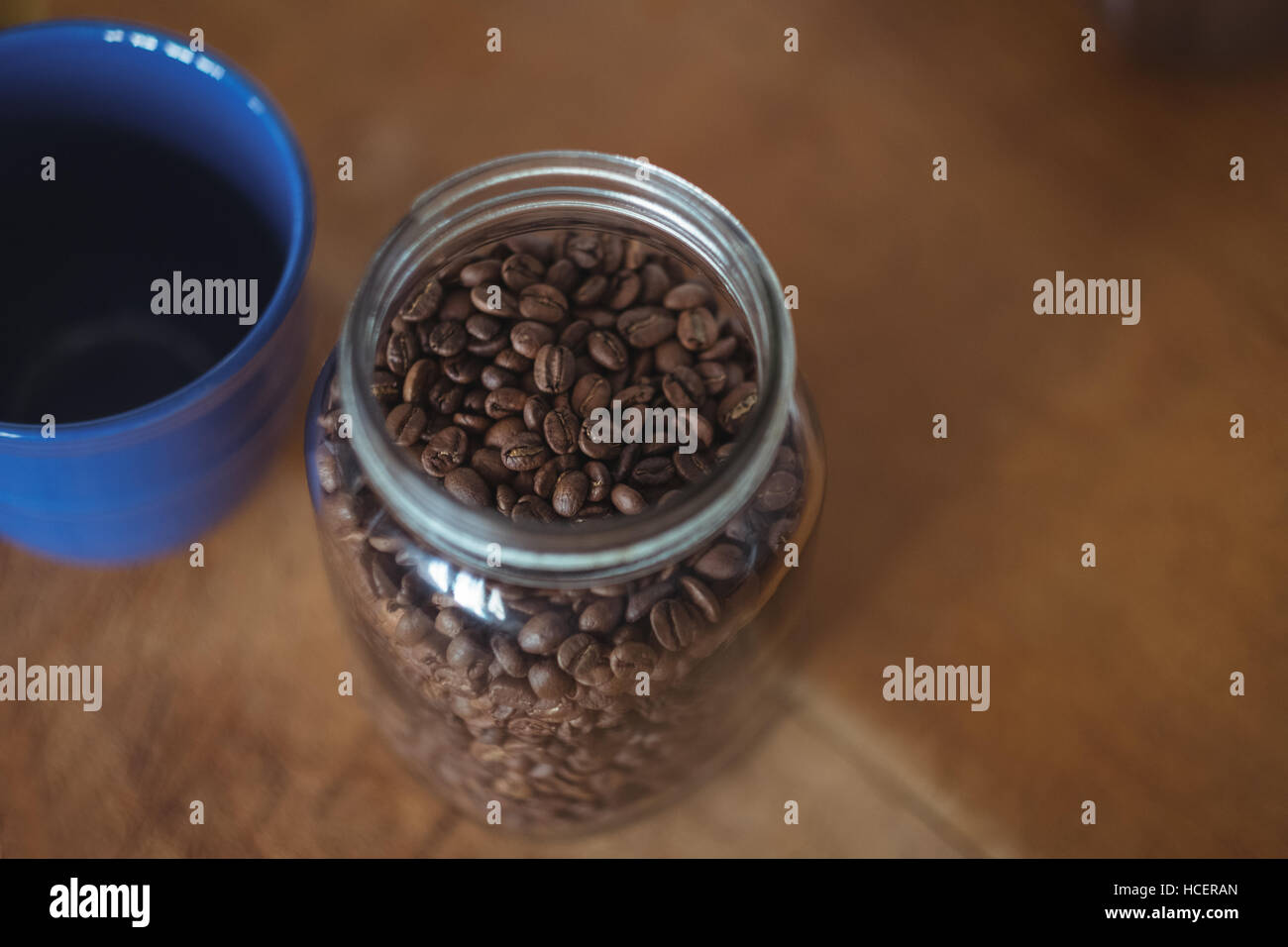 Glas mit gerösteten Kaffeebohnen und Kaffeetasse Stockfoto