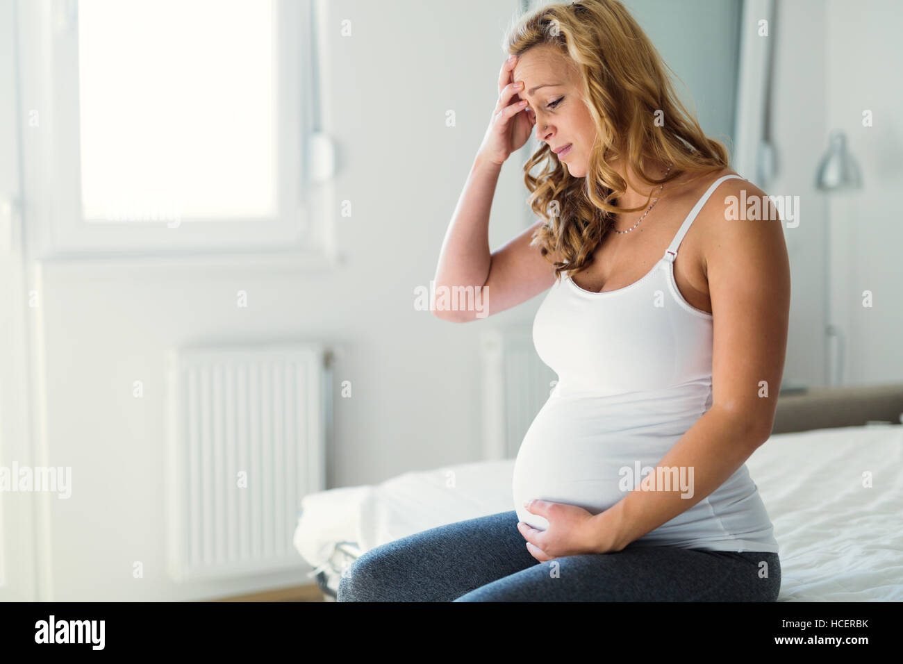 Schwangere Frau mit Kopfschmerzen und Übelkeit leiden Stockfoto