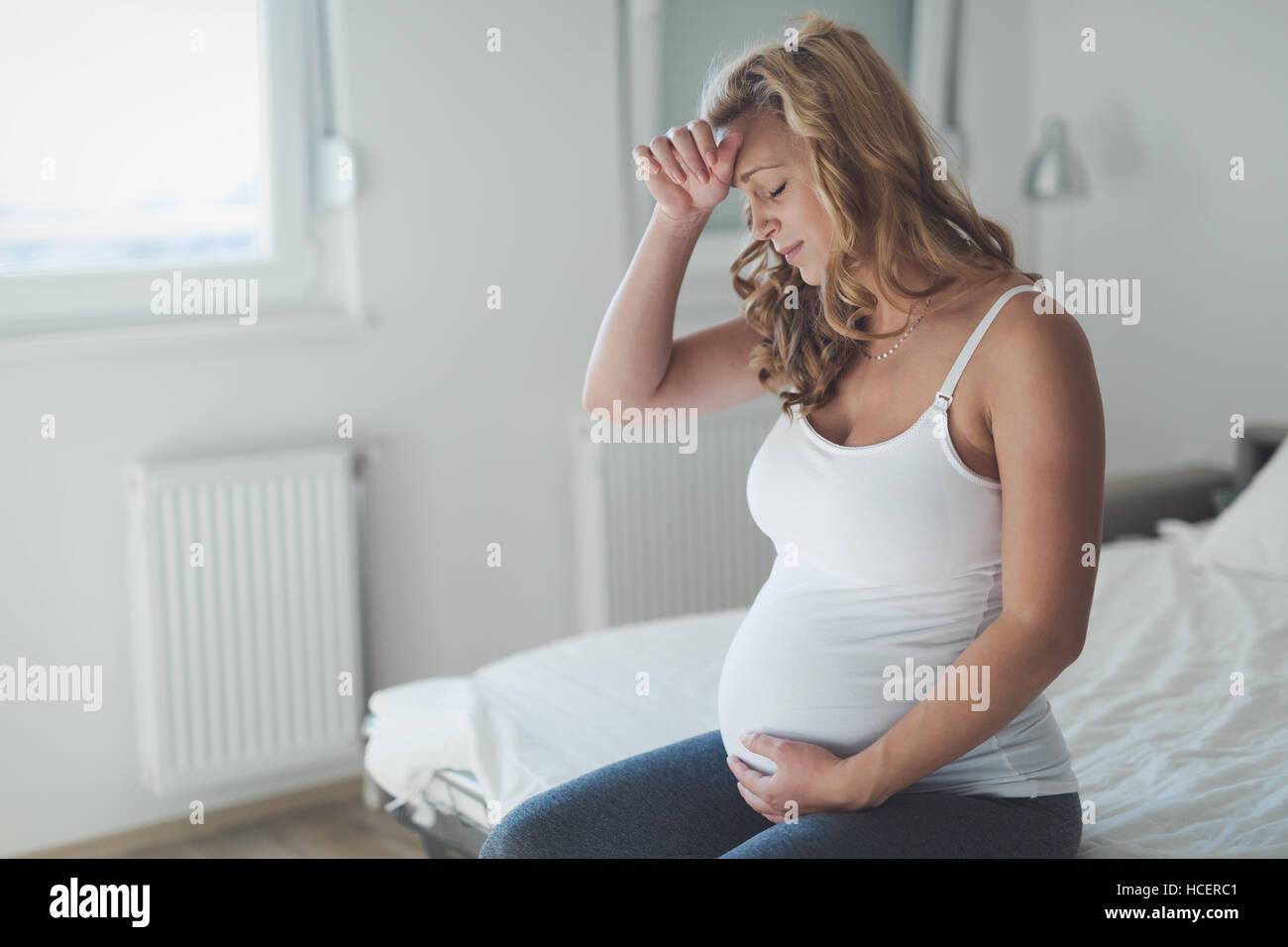 Schwangere Frau mit Kopfschmerzen und Übelkeit leiden Stockfoto