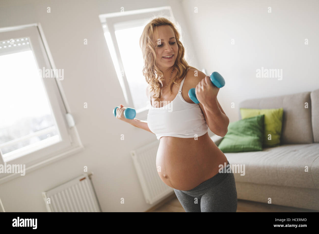 Schwangere Frau training mit Hanteln, aktiv zu bleiben Stockfoto