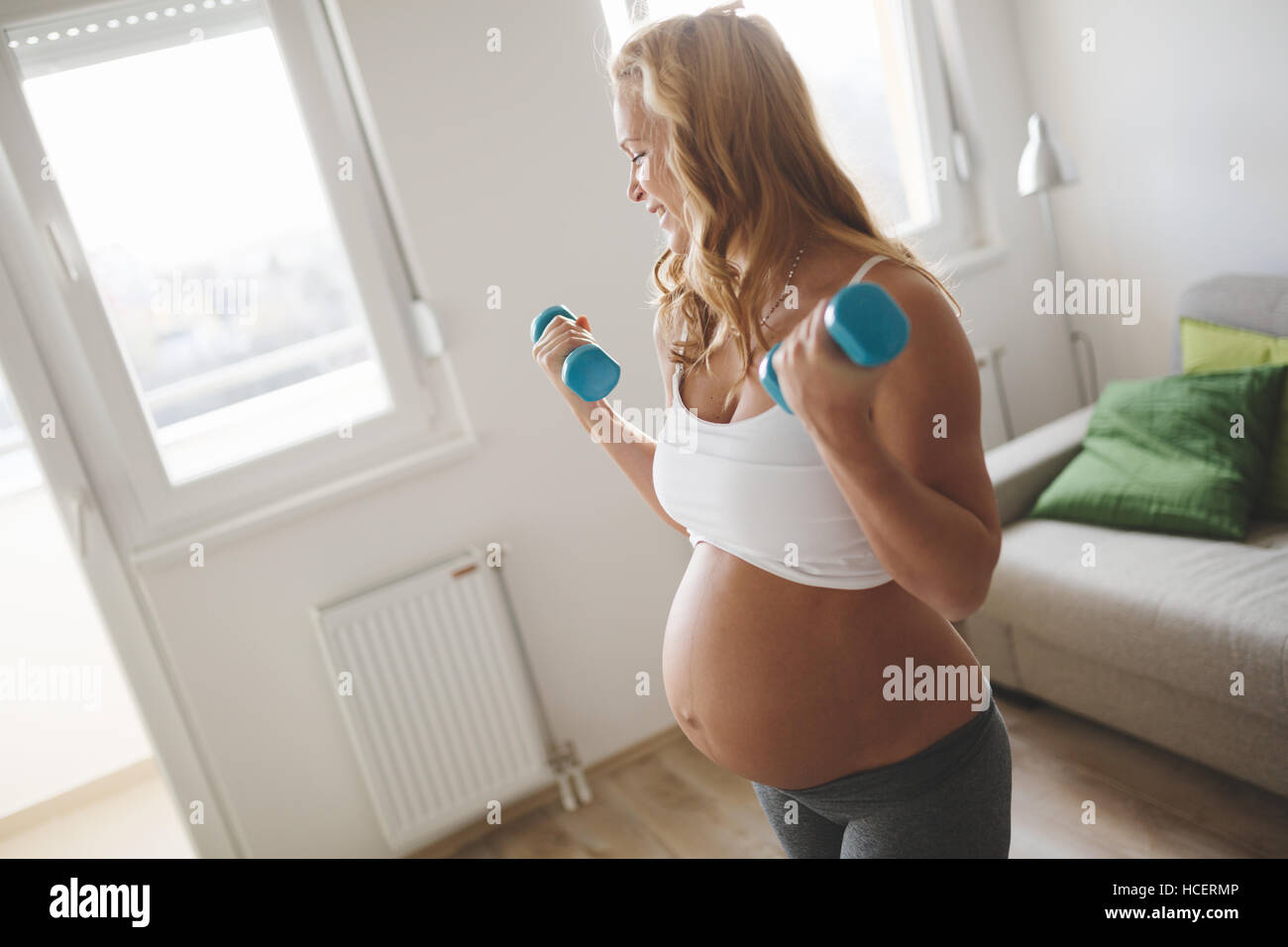Schwangere Frau training mit Hanteln, aktiv zu bleiben Stockfoto
