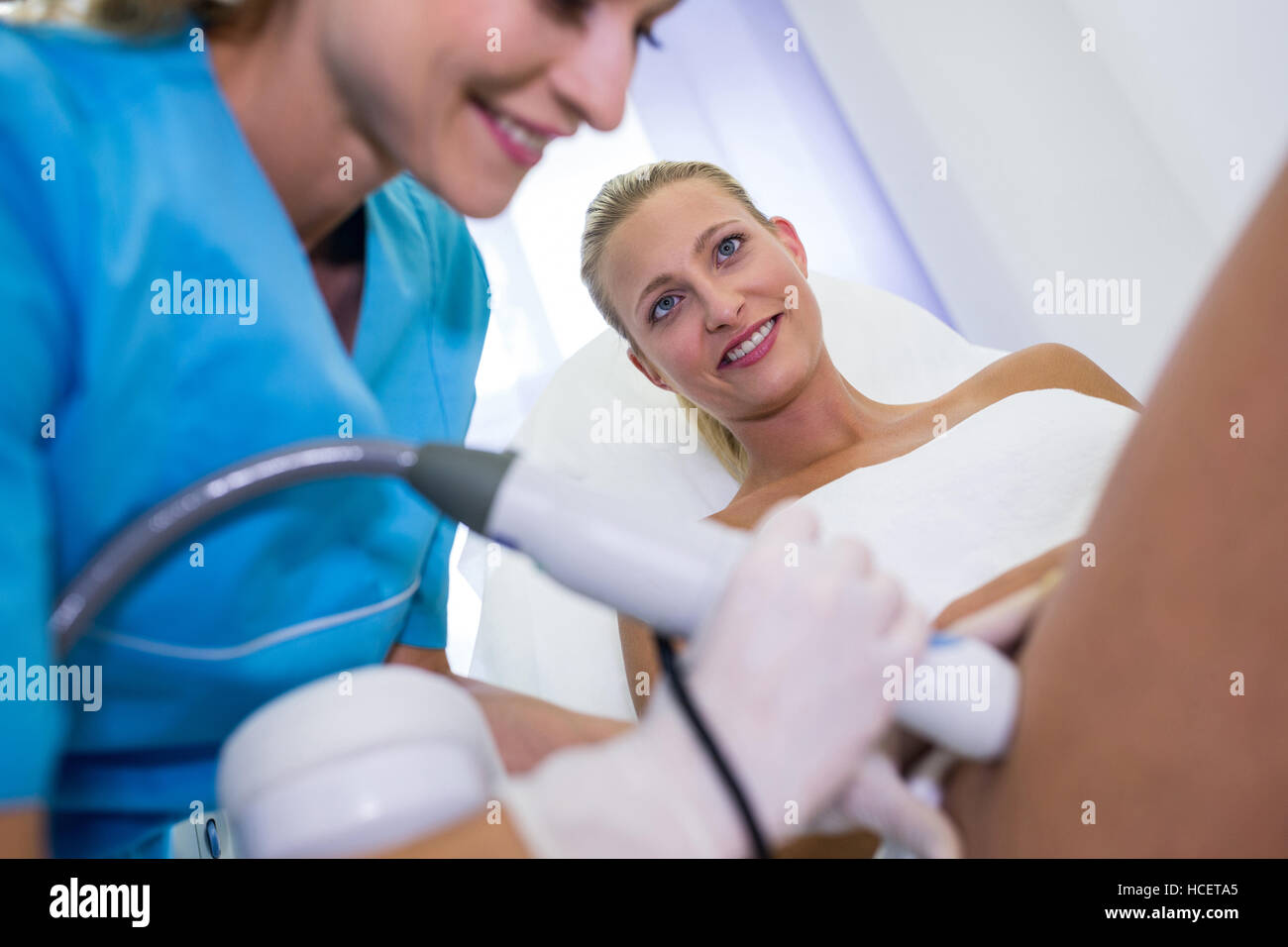 Frau, die Laser Epilation Behandlung auf ihren Oberschenkel Stockfoto