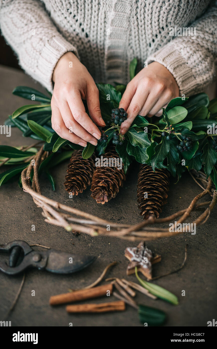 Frau arbeitet an Weihnachtskranz Stockfoto