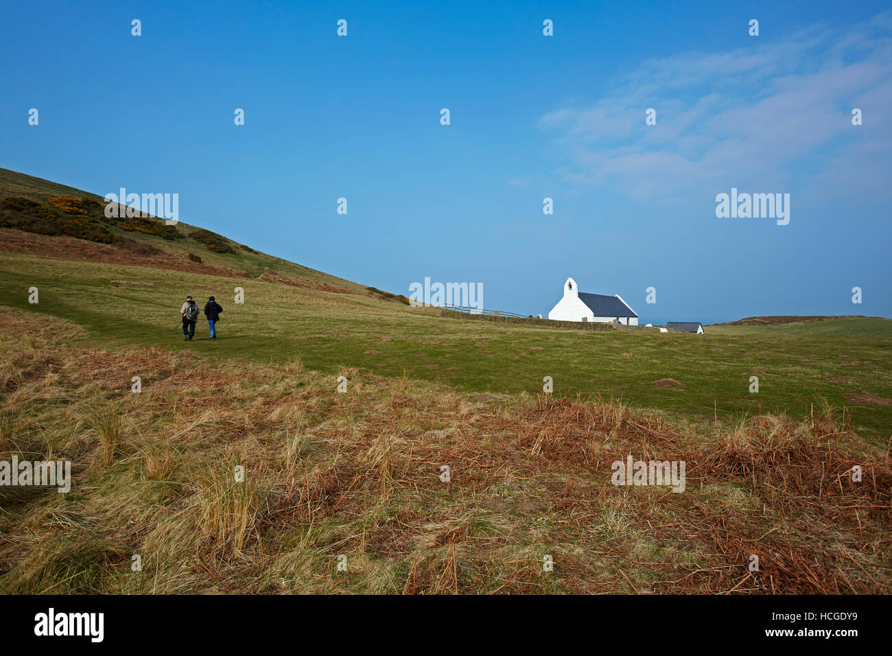 Zwei Wanderer vorbei an Mwnt Kirche (Kirche des Heiligen Kreuzes) Cardigan Bay, Ceredigion, Wales, UK Stockfoto
