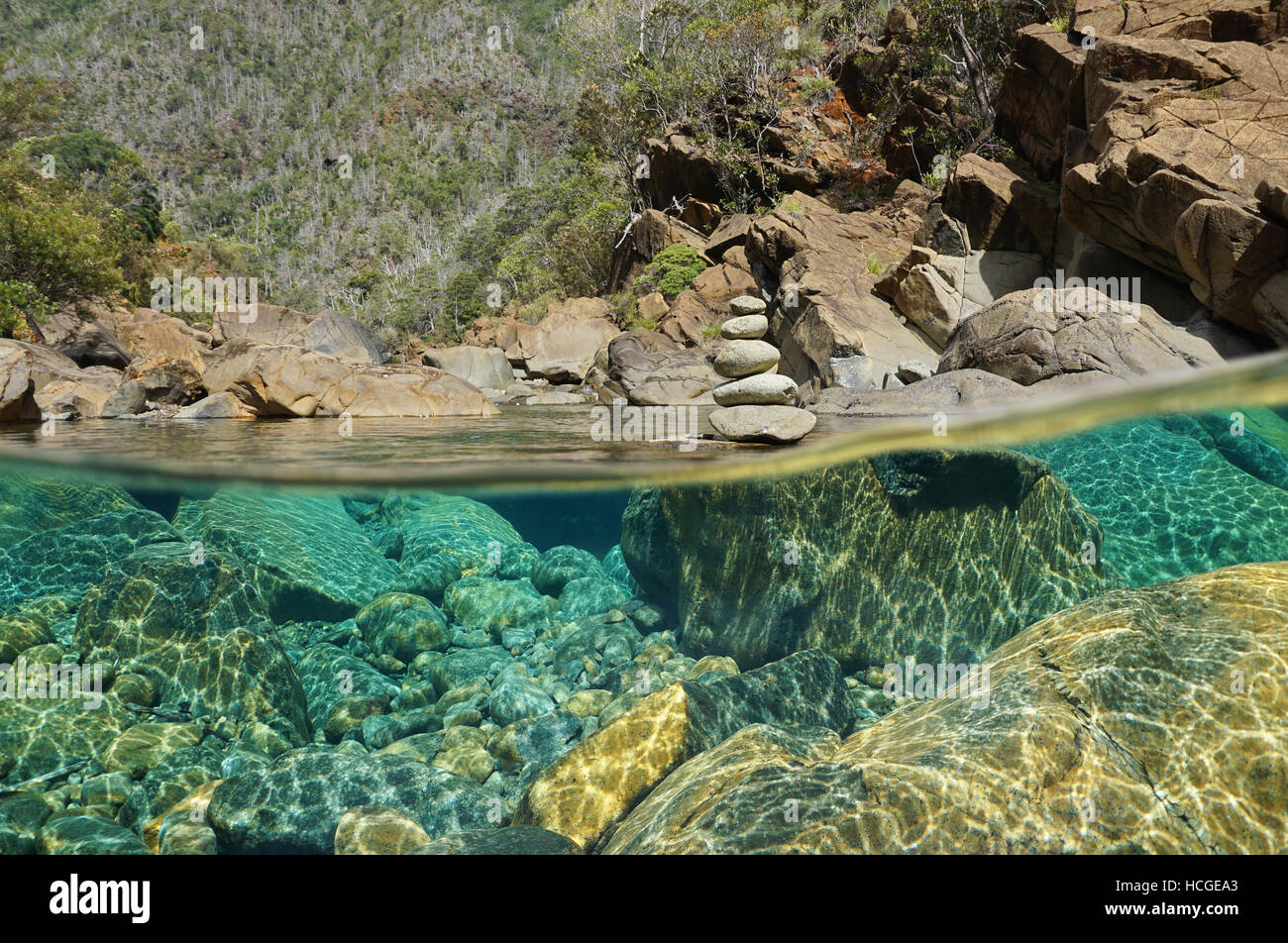 Über und unter Wasser im Fluss mit Steinen auf das Flussbett unter Wasser und einen Stapel von Kieselsteinen über Oberfläche, Dumbea, Neu-Kaledonien Stockfoto