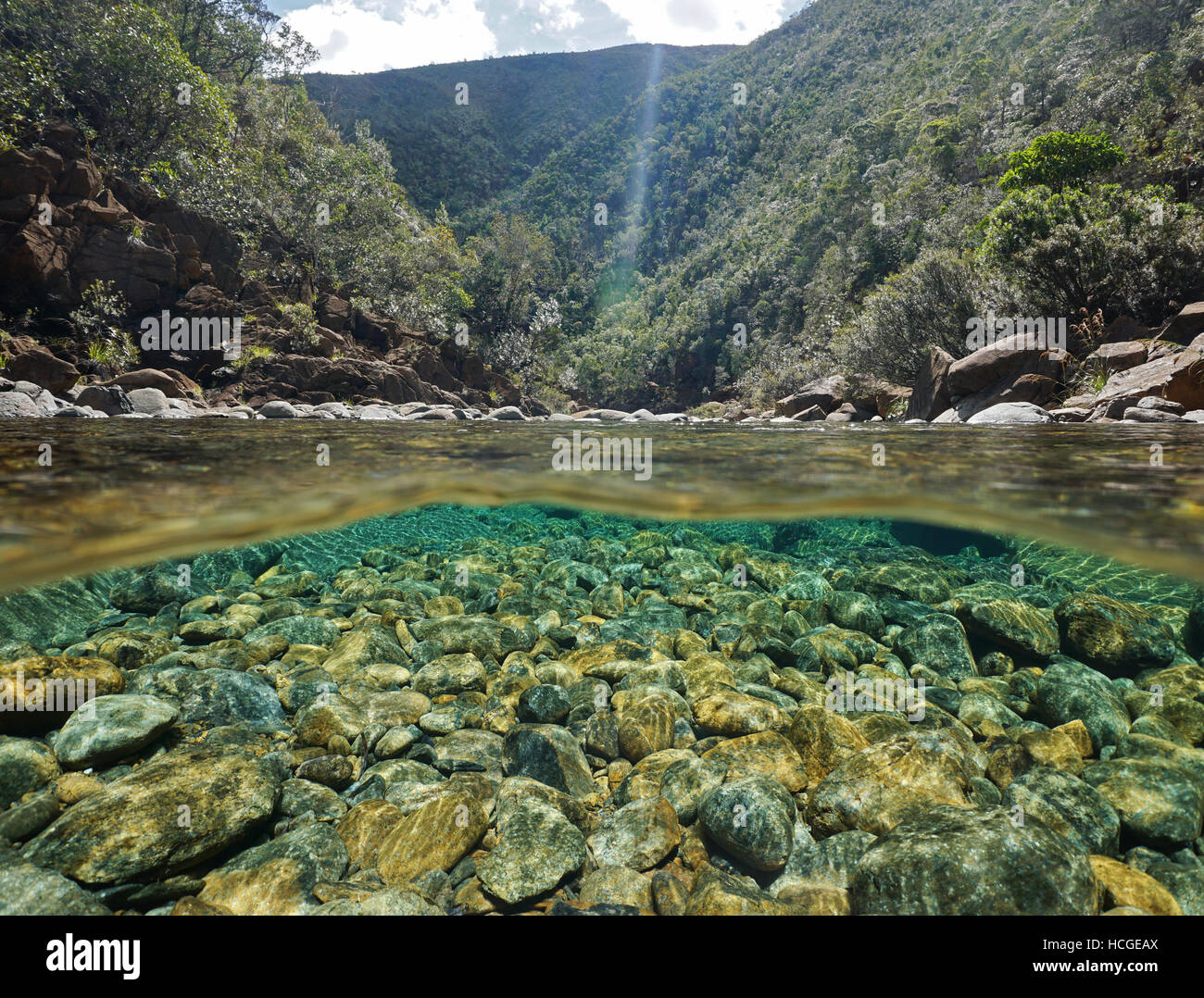 Fluss oberhalb und unterhalb der Wasseroberfläche mit Steinen auf dem Flussbett Unterwasser, Dumbea Fluss, Neu-Kaledonien Stockfoto