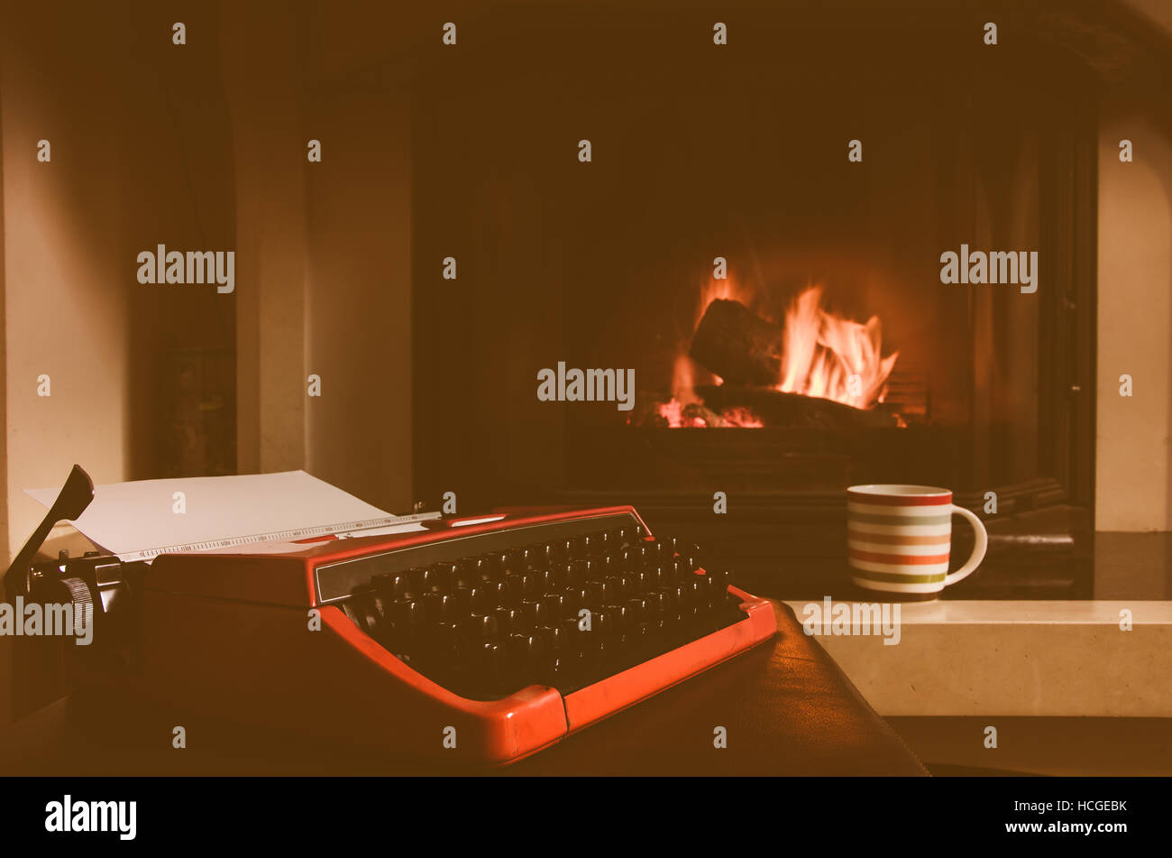 Alte Schreibmaschine und eine Tasse Kaffee vor Kamin Stockfoto