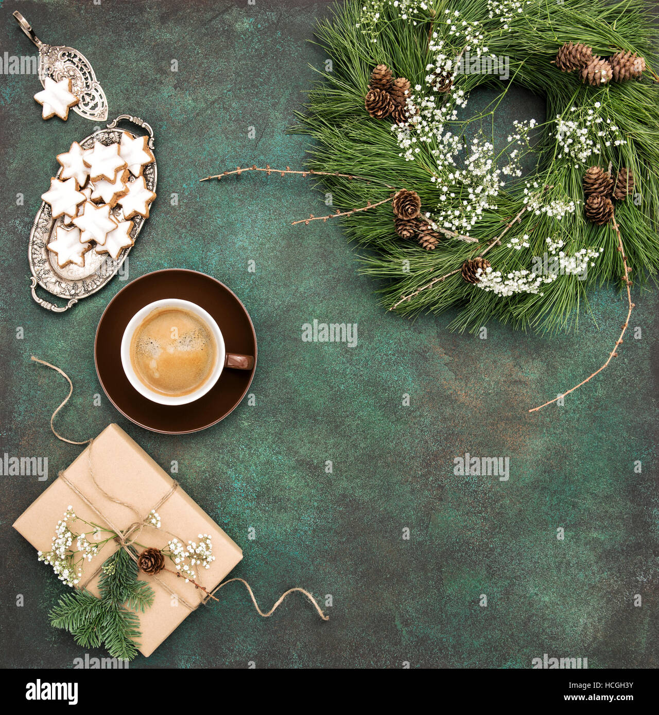 Weihnachtskranz, Sterne Cookies, Kaffee und verpacktes Geschenk. Reisen Essen Hintergrund Stockfoto
