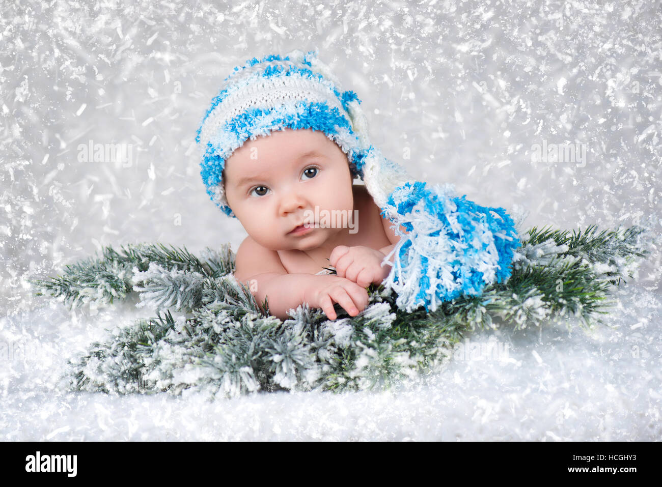 Neugeborenes Baby in einer Strickmütze. Schnee-Hintergrund Stockfoto