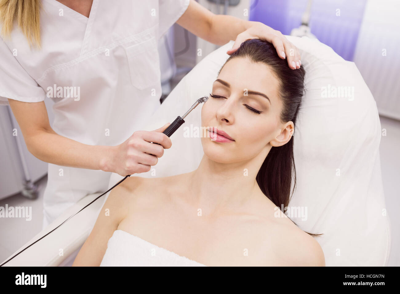 Hautarzt Laser-Haarentfernung am Patienten durchführen Stockfoto