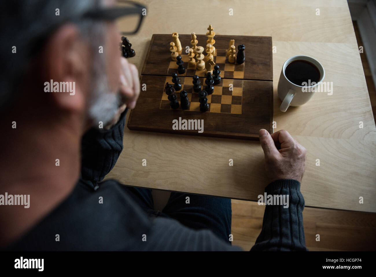 Aufmerksamen Mann spielt Schach Stockfoto