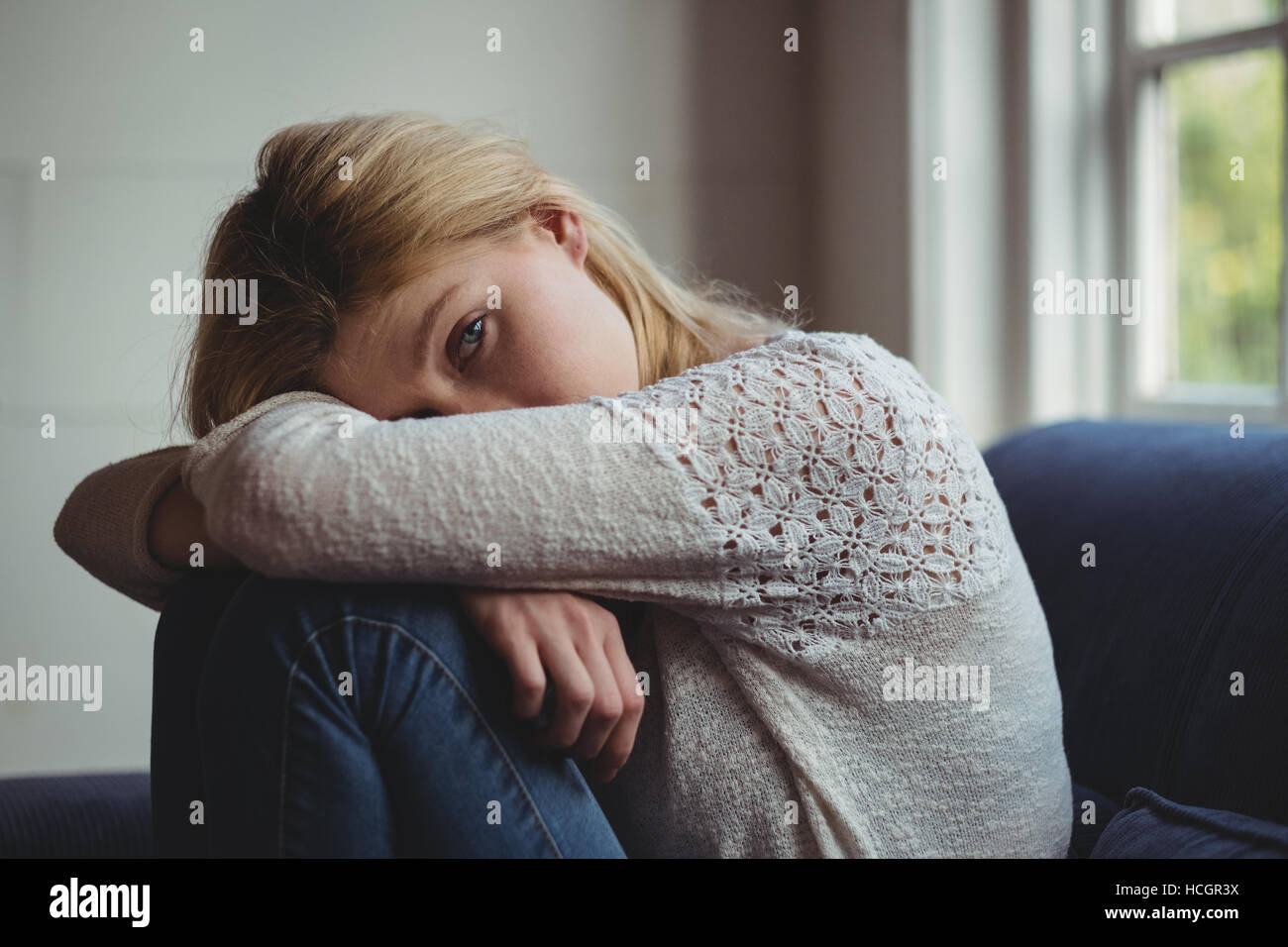 Porträt schöne Frau sitzt auf dem Sofa im Wohnzimmer Stockfoto