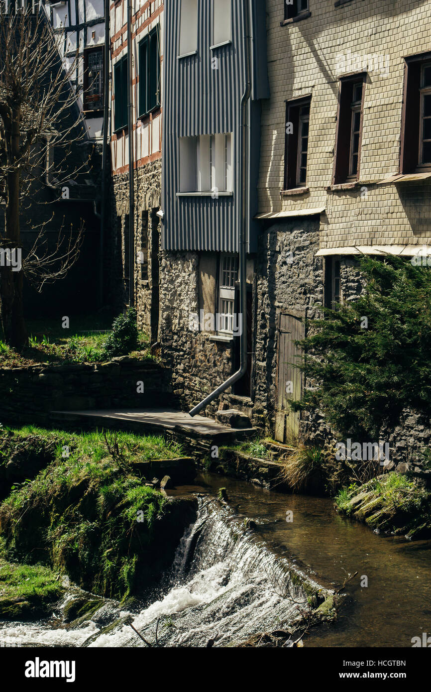 Ein kleiner Wasserfall des Flusses Ruhr neben einigen Gebäuden in Monschau. Stockfoto