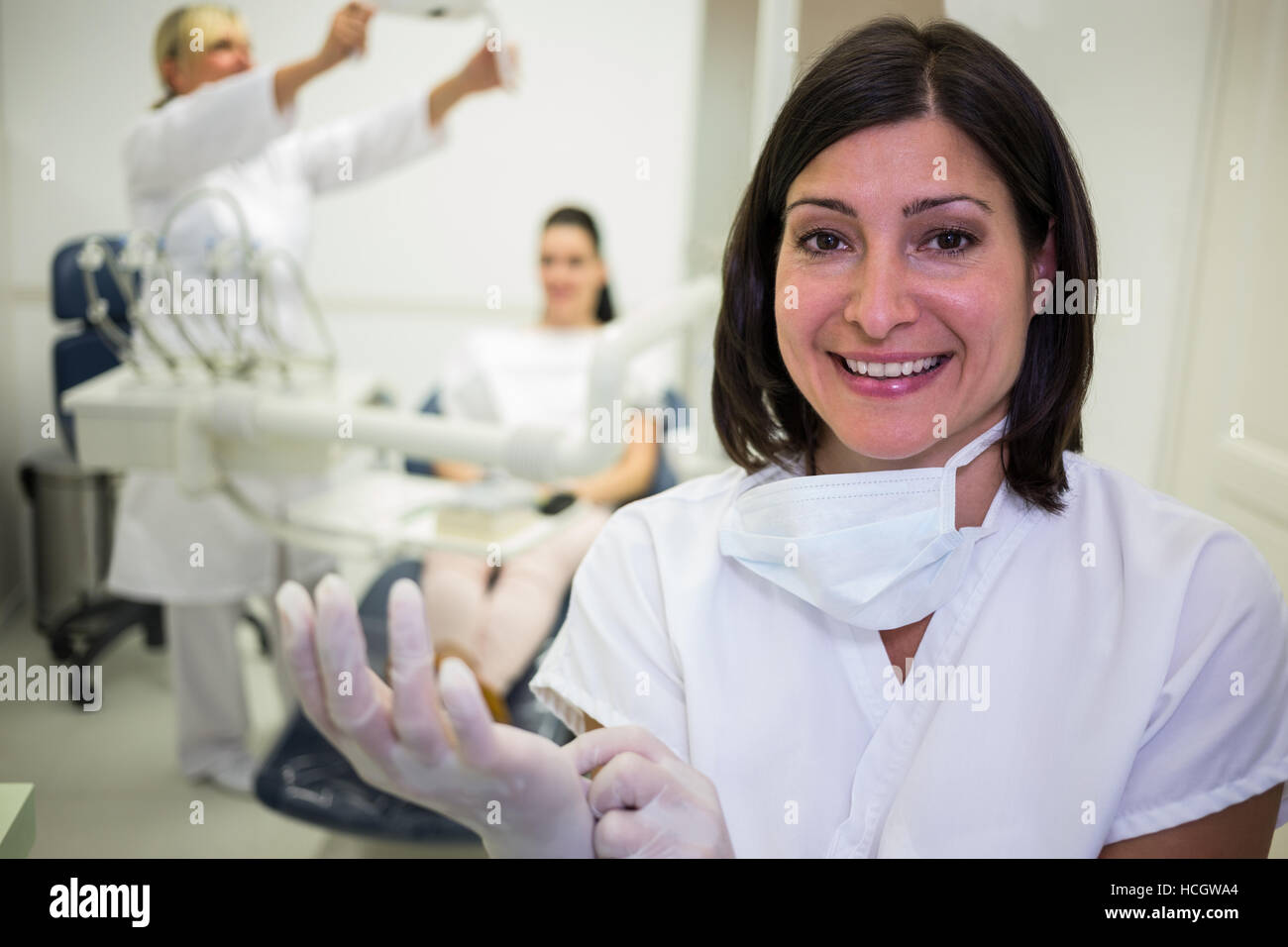 Lächelnde Zahnarzt OP-Handschuhe tragen Stockfoto