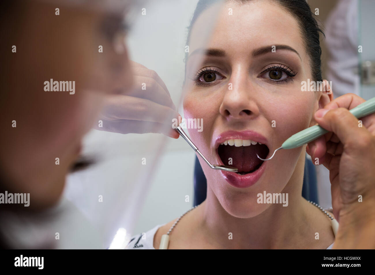Zahnarzt untersucht eine Patientin mit Werkzeugen Stockfoto