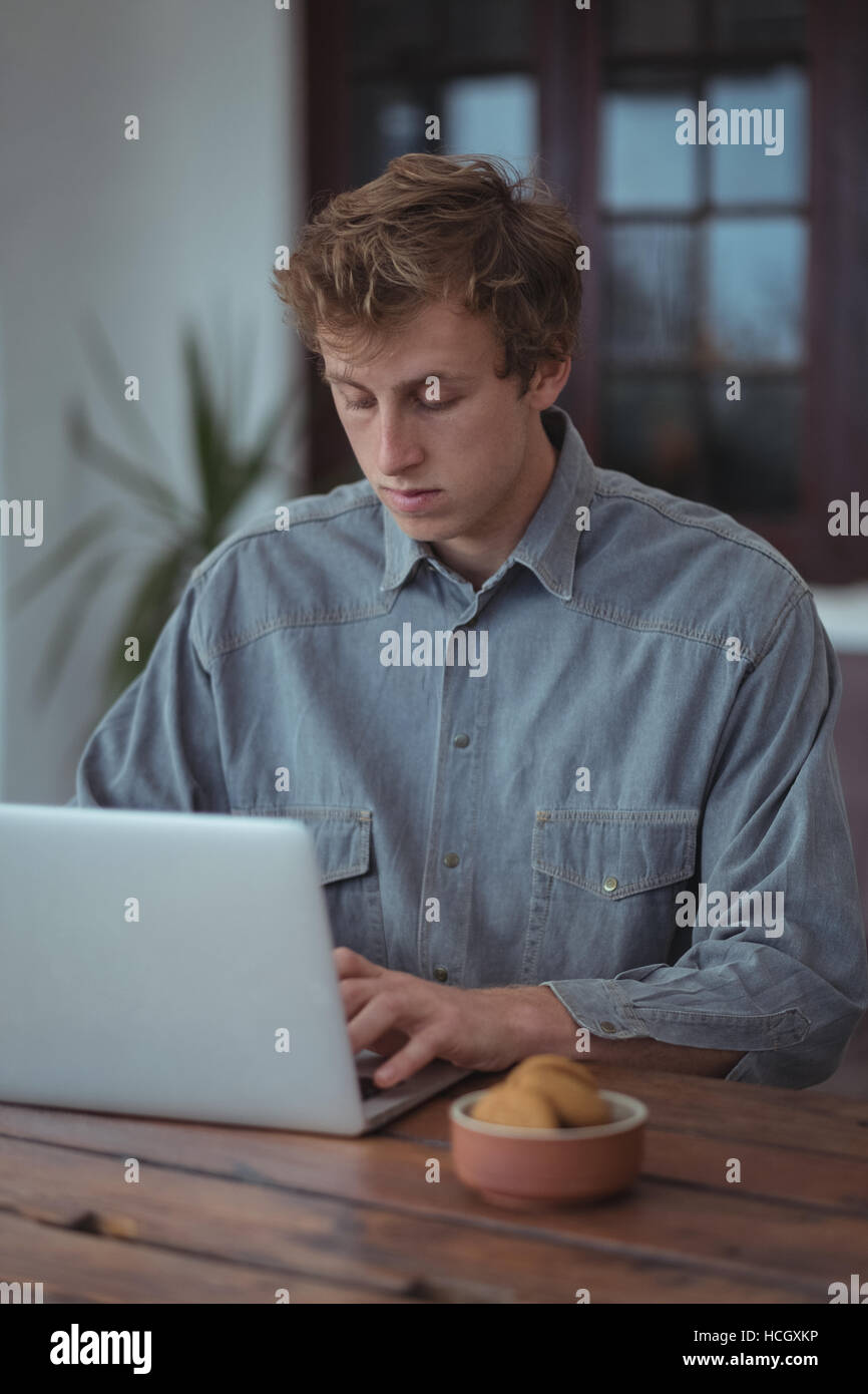 Mann mit Laptop am Schreibtisch Stockfoto
