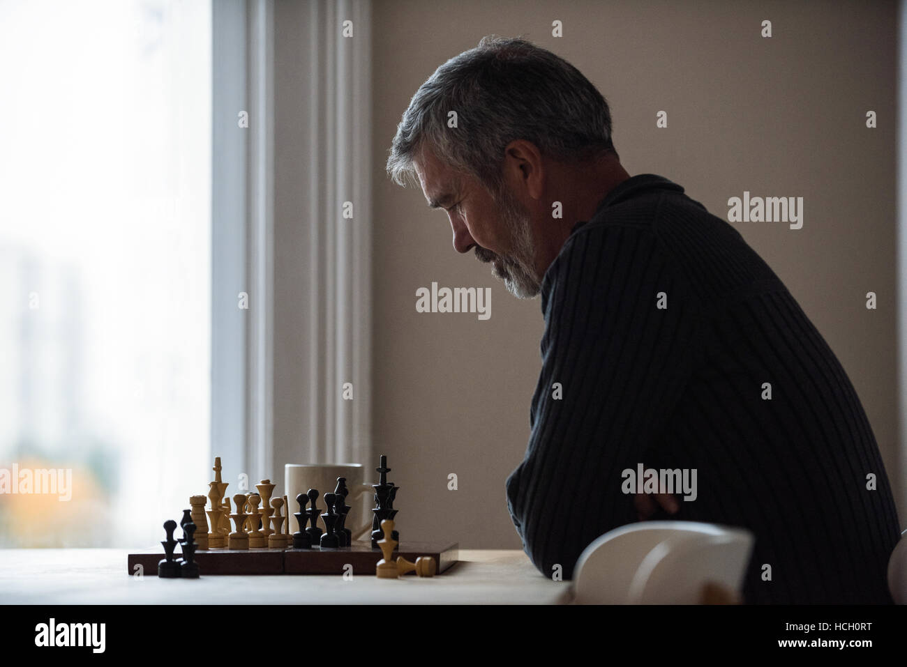 Aufmerksamen Mann spielt Schach Stockfoto