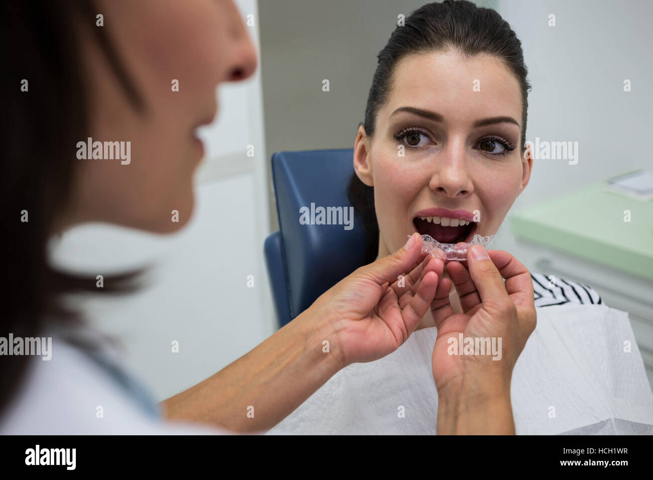 Zahnarzt, die Unterstützung eines Patienten, unsichtbare Zahnspange zu tragen Stockfoto