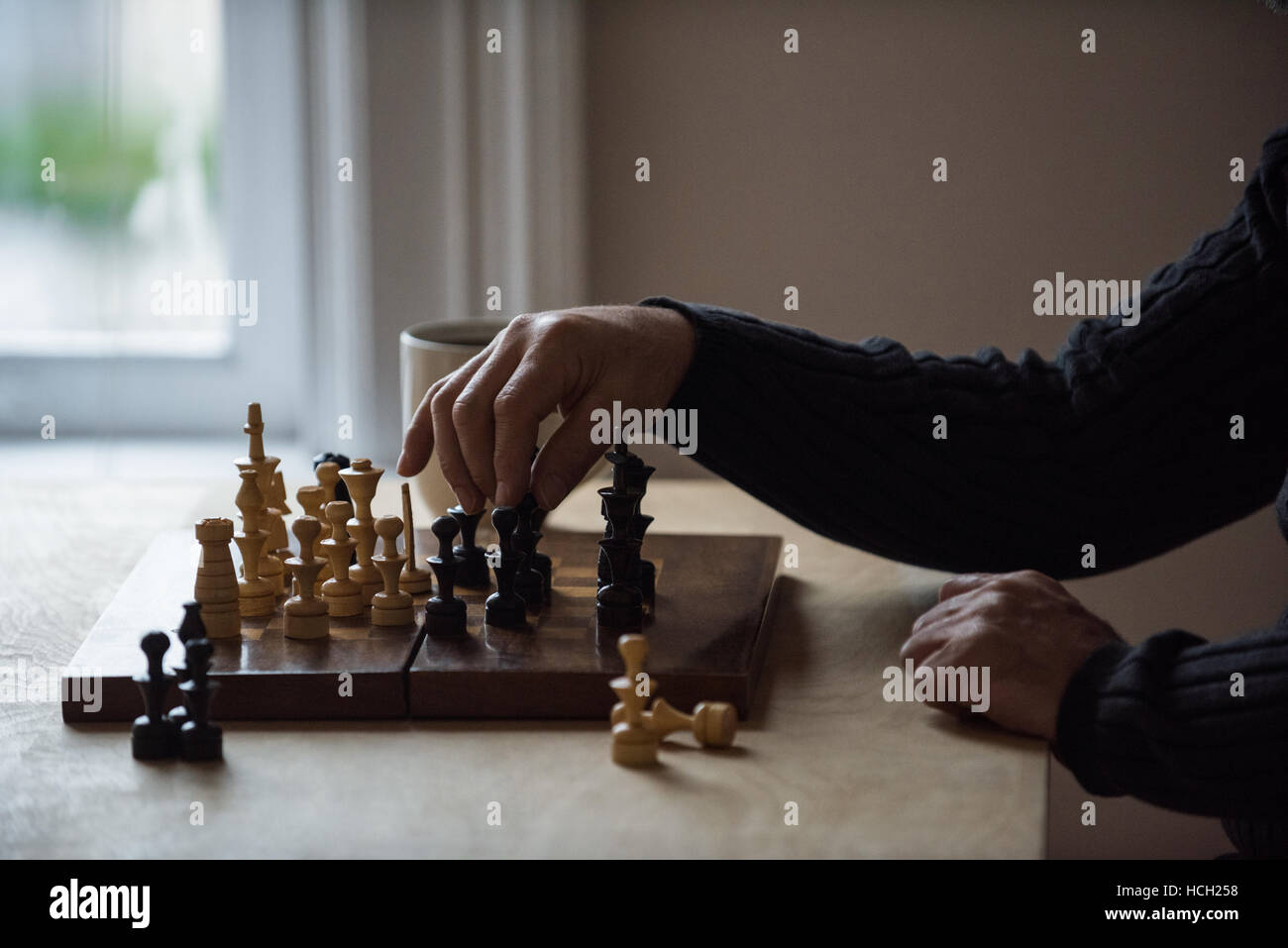 Mann spielt Schach zu Hause Stockfoto