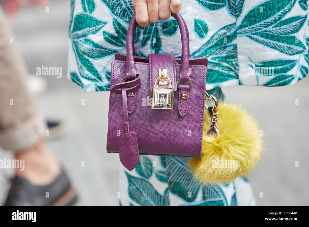 Frau mit lila Patrizia Pepe Tasche vor Giorgio Armani-Modenschau, Milan Fashion Week Streetstyle am 23. September 2016. Stockfoto