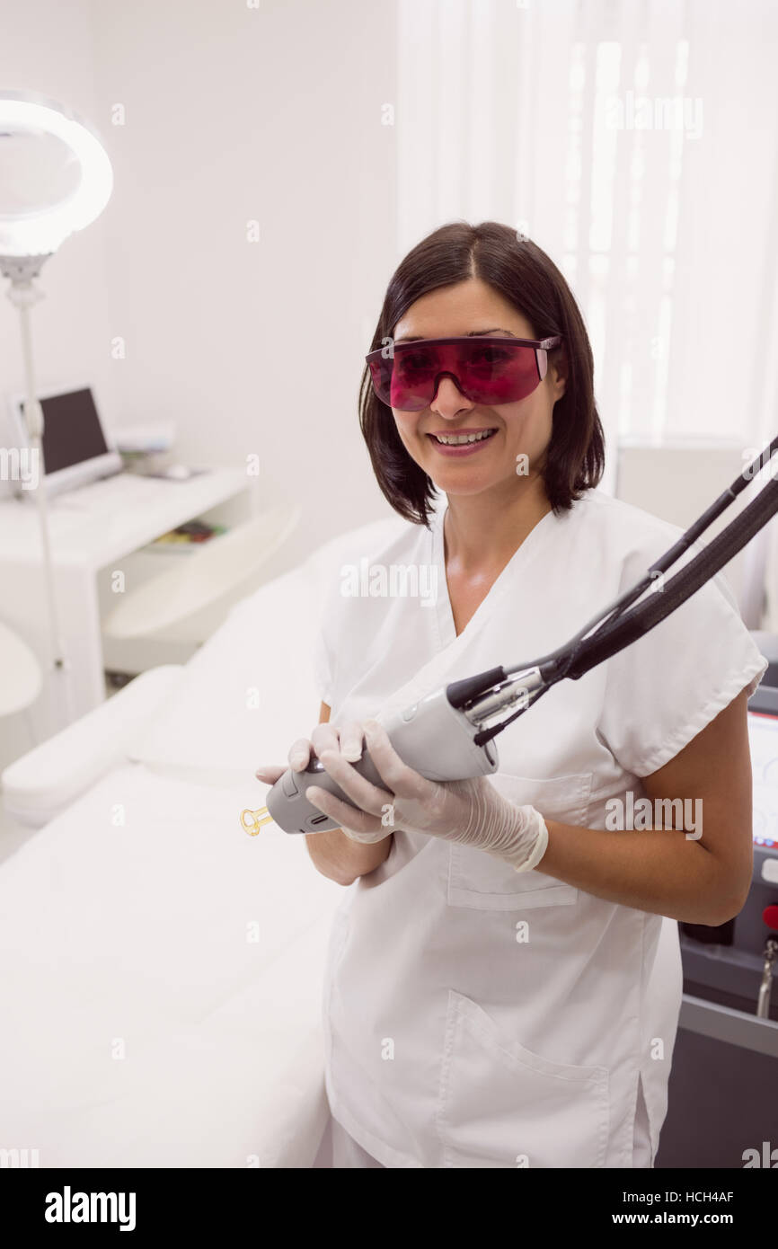 Arzt in Schutzbrille hält ein Epilierer Stockfoto