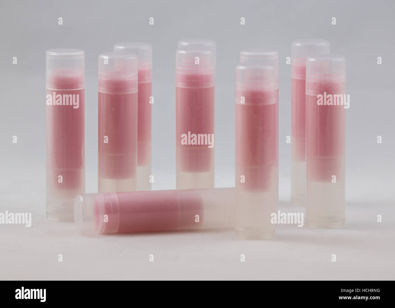 Anordnung der vielen klaren Chapstick förmigen Röhren mit Pint Inhalt auf weißem Hintergrund Stockfoto