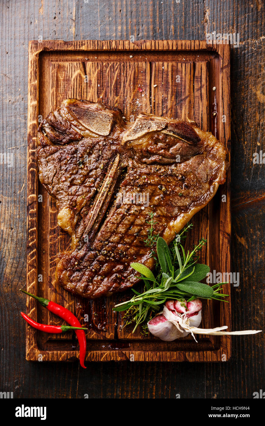 Gegrilltes T-Bone-Steak auf dem Board auf hölzernen Hintergrund Stockfoto