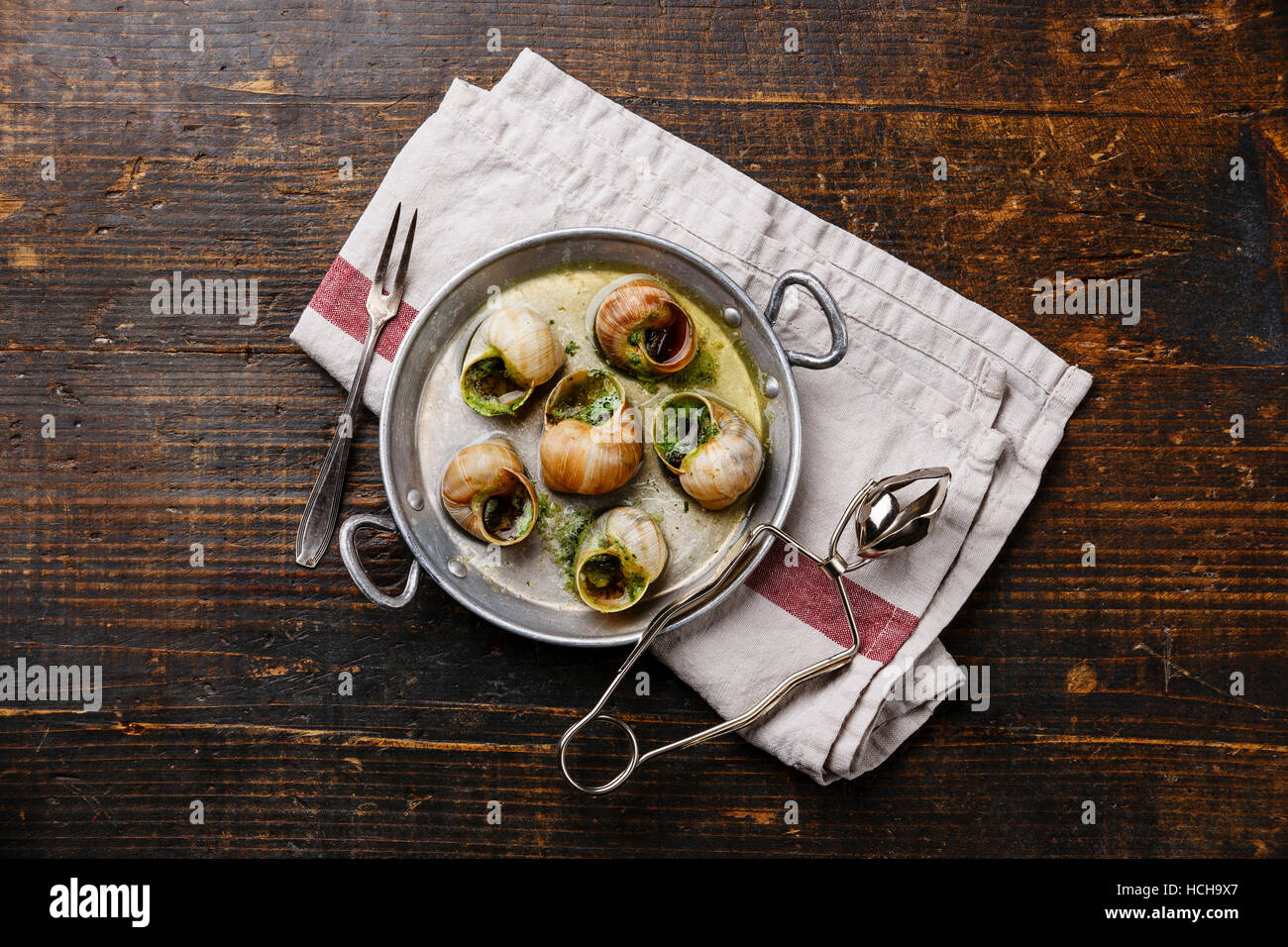Bourgogne Schnecken Schnecken mit Knoblauch-Kräuter-Butter in Aluminium Pfanne auf rustikalen hölzernen Hintergrund Stockfoto