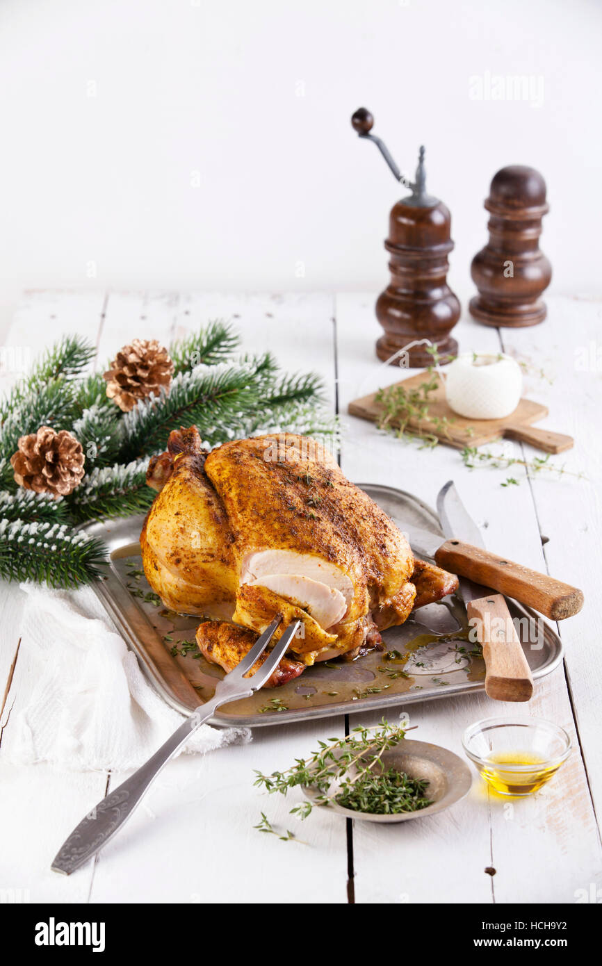 Ganz gebratenes Huhn und grüne Tanne Weihnachten Zweig auf weißem Holz Hintergrund Stockfoto