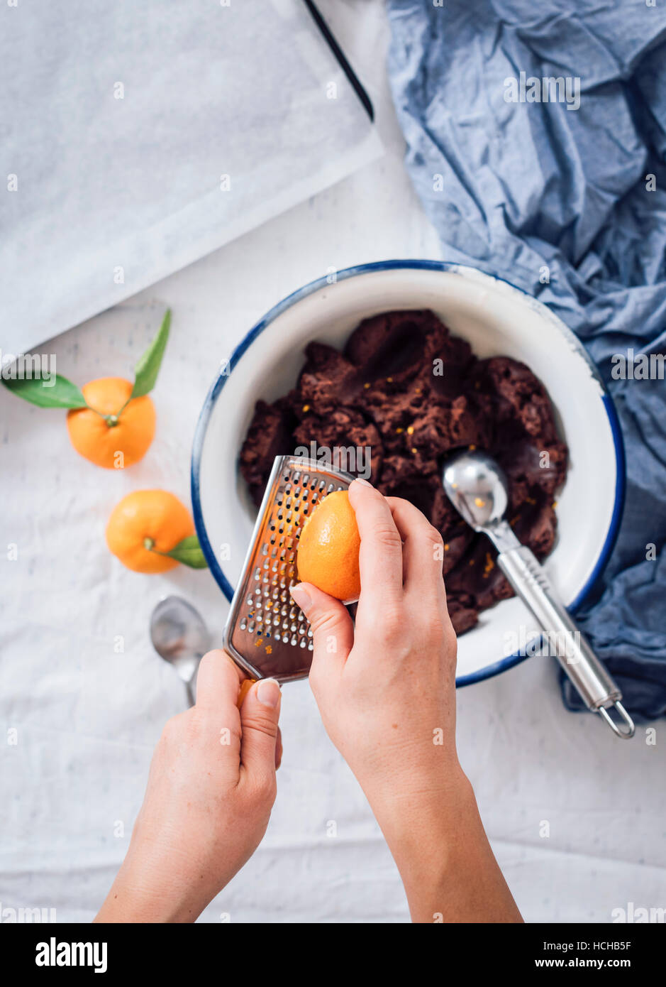 Hände reiben Mandarin Lebensfreude zu einem Schoko-Cookie-Teig. Stockfoto