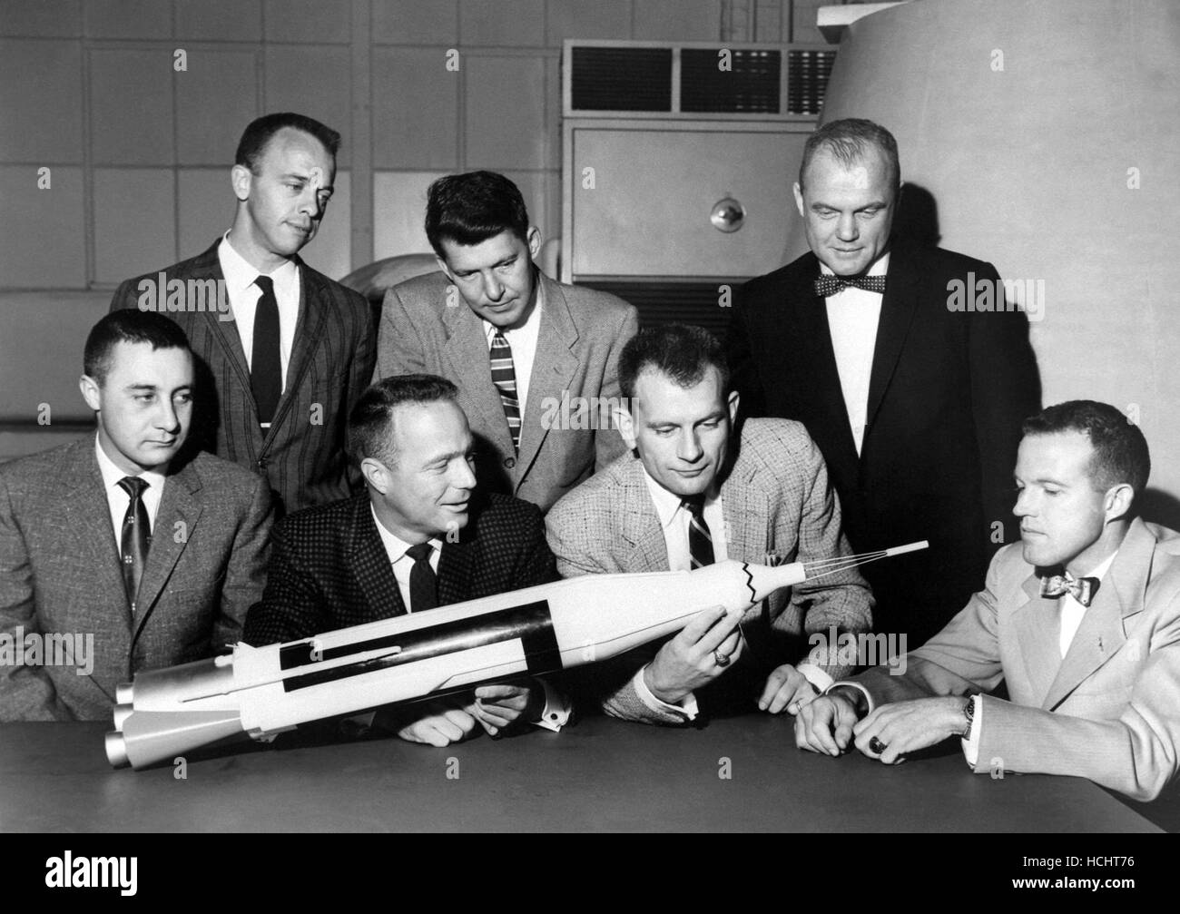 Die ursprünglichen 7 Mercury-Astronauten sind um einen Tisch bewundern eine Atlas-Modell am 30. April 1959 abgebildet. Stehend, links nach rechts sind Alan B. Shepard, Jr., Walter M. Schirra, Jr., und John H. Glenn, Jr.; sitzend, links nach rechts sind Virgil I. Grissom, M. Scott Carpenter, Donald Slayton und L. Gordon Cooper, Jr. Die 7 Mercury-Astronauten wurden in der amerikanischen Öffentlichkeit im April 1959 eingeführt. Die sieben Kriterien für die Auswahl waren wie folgt: 1. weniger als 40 Jahre alt; (2) weniger als 5 Fuß 11 Zoll hoch: 3. ausgezeichnete Kondition; 4. Bachelor-Abschluss in Maschinenbau oder gleichwertig; 5. Test-pilot Stockfoto