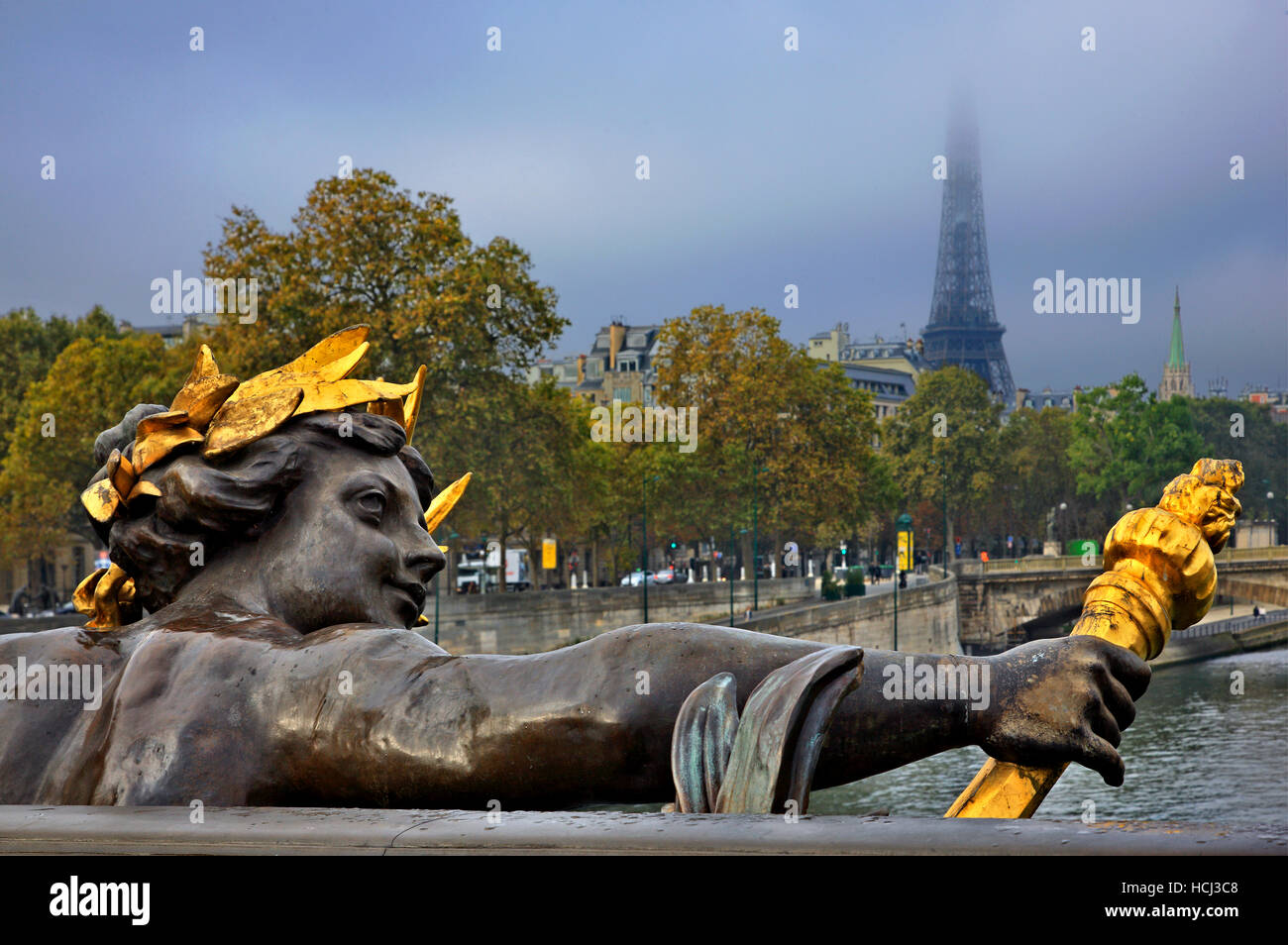 Skulptur auf Pont Alexandre III, Paris, Frankreich. Im Hintergrund, der Eiffelturm in den Wolken versteckt Stockfoto